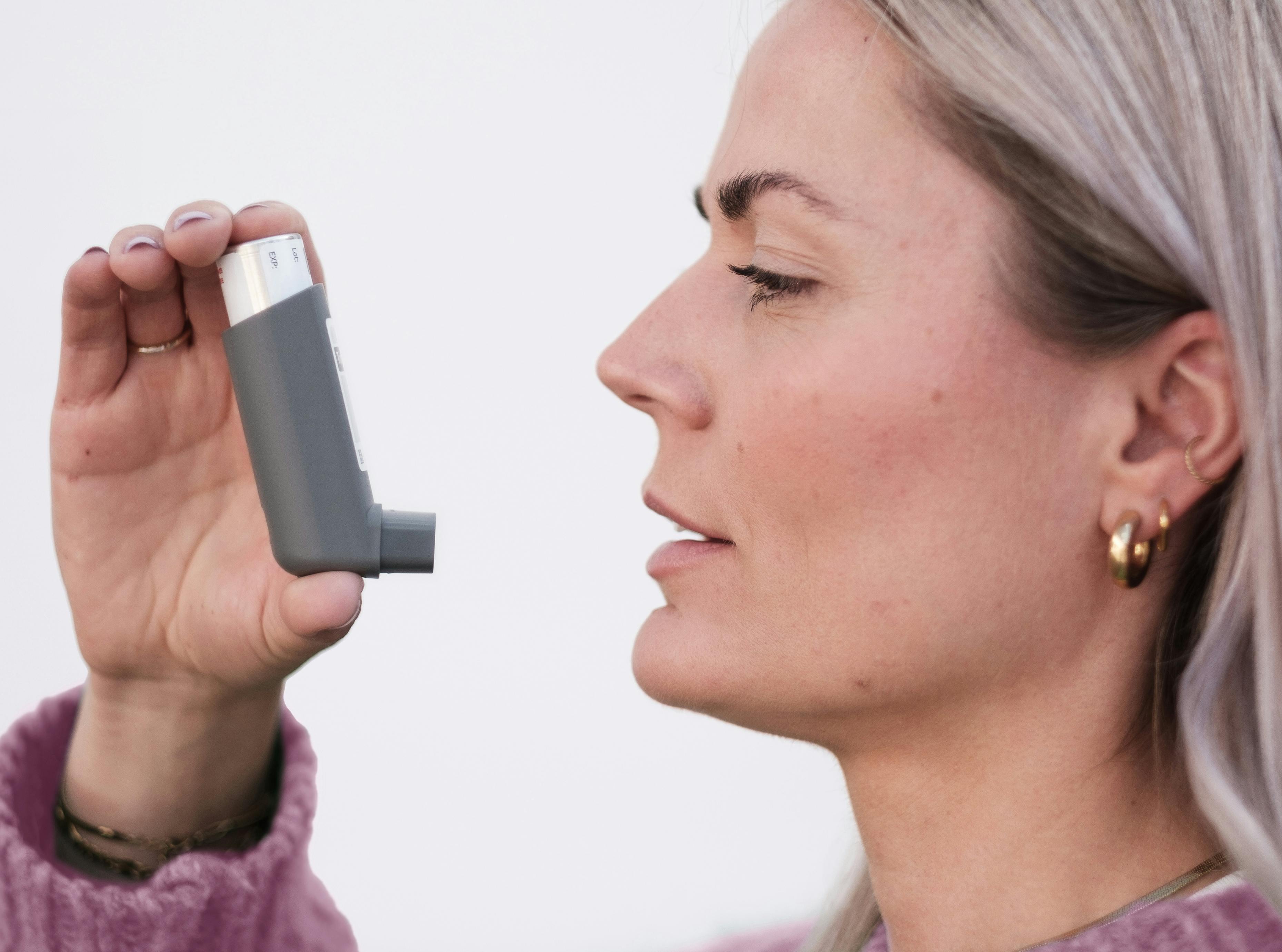 Person using asthma inhaler